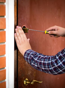 closeup shot of Locksmith Hallandale Beach FL carpenter fixing door lock with screwdriver